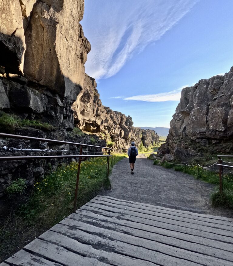 thingvellier park in iceland man walking on a pathway between rocks