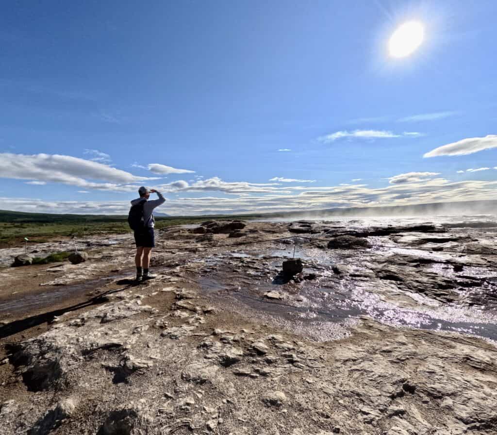 man standing at Geothermal Area in Iceland and looking out over the sulphur pools