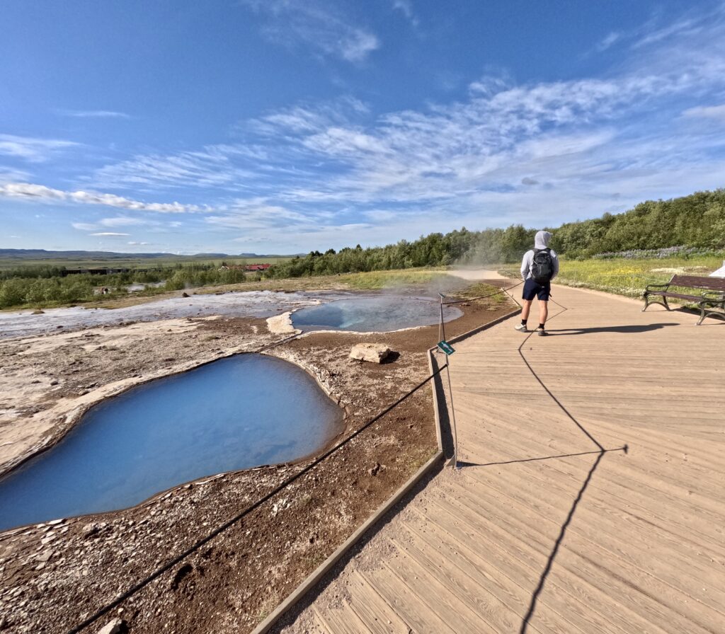 tourist visiting sulphur pools in geothermal area of golden circle iceland