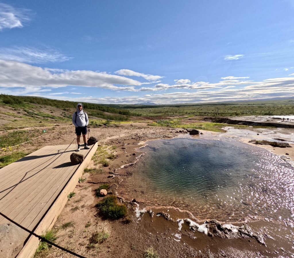 tourist visiting sulphur pools in geothermal area of golden circle iceland