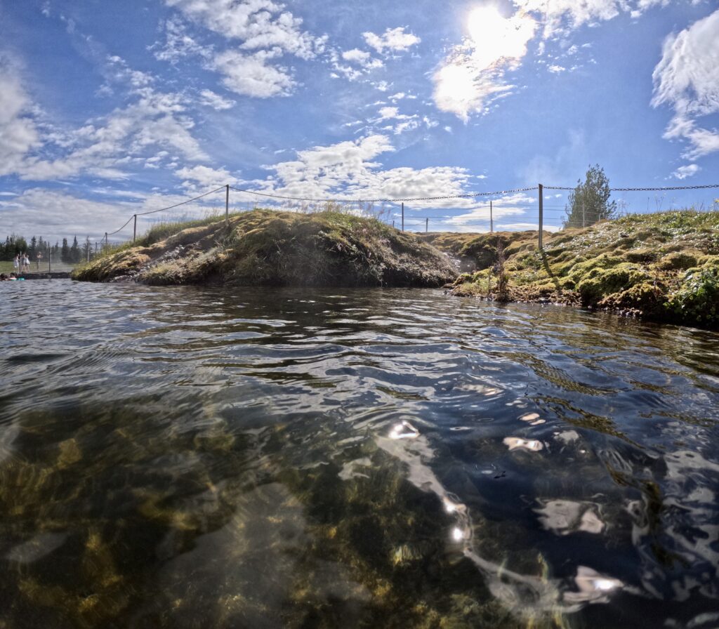 tourist couple visiting ssecret lagoon along golden circle iceland