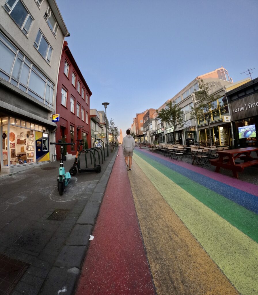 tourist walking on rainbow road in reykjavik iceland during midnight sun