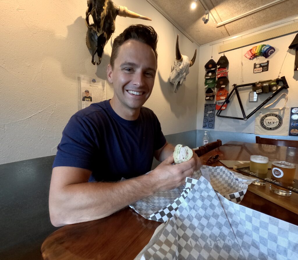 tourist visiting bozeman brewing company with sandwich