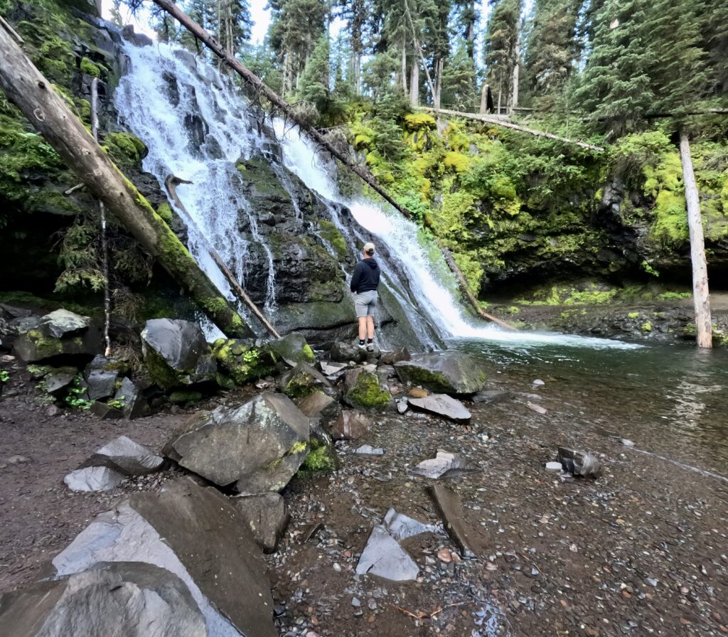 tourist couple hiking grotto falls trail in montana