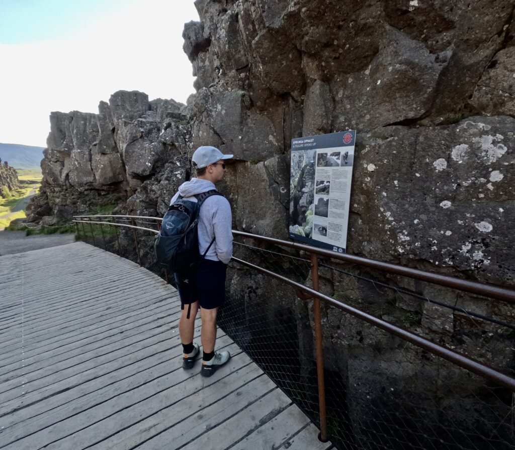 tourist looking at informational sign in thingvellir national park golden circle iceland