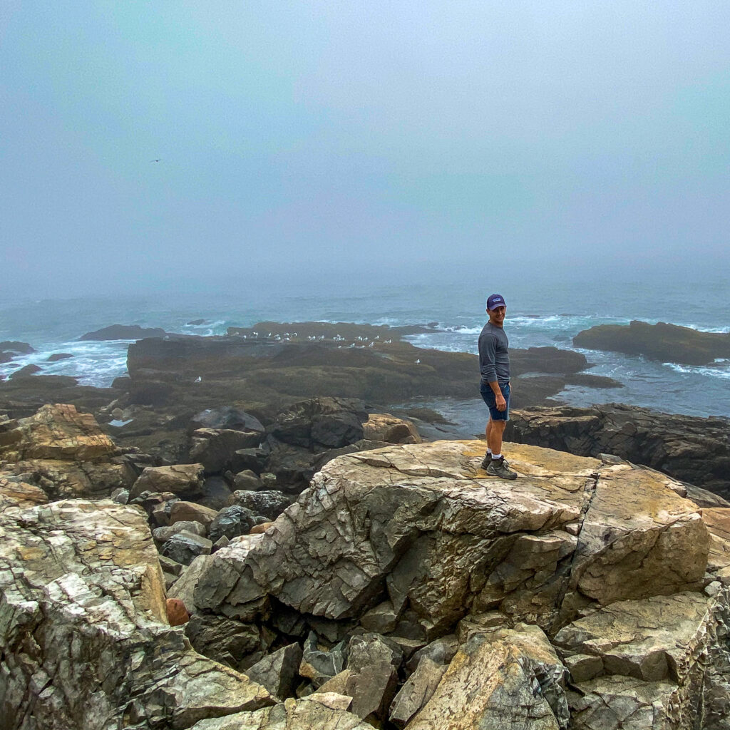 Man standing on a rock on the Bar Harbor, Maine coastline